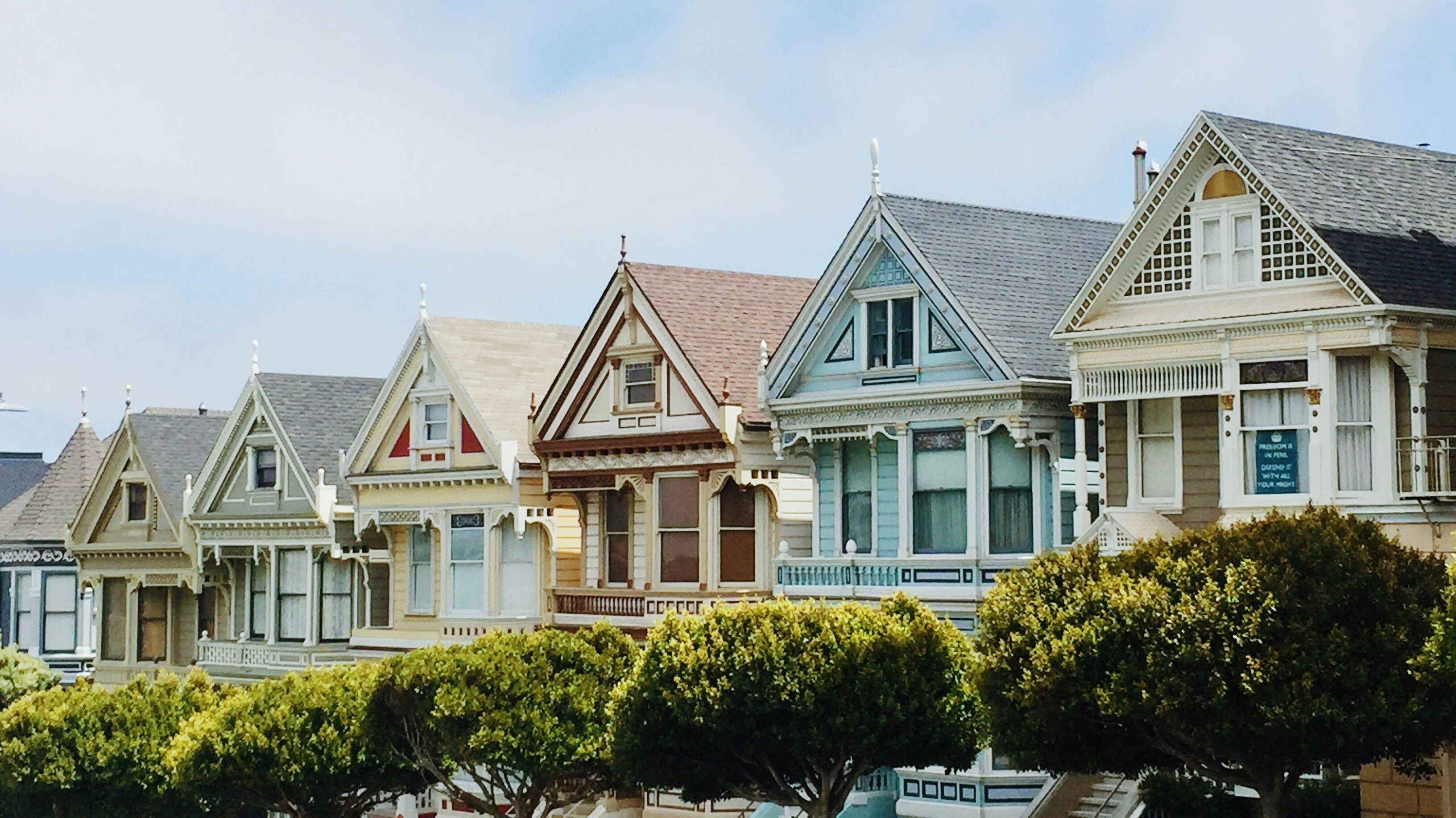 Row of colorful Victorian-style homes representing different construction types, a key factor in COPE Insurance risk assessment.