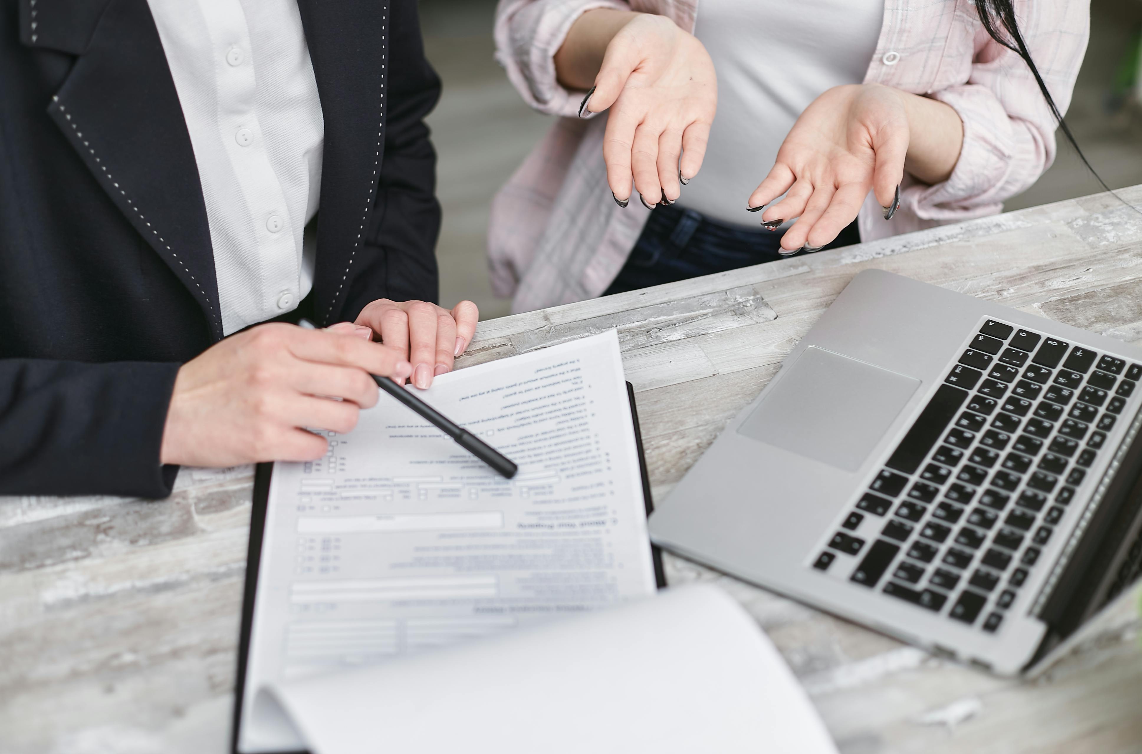An insurance agent explaining the CG 2404 Endorsement Waiver of Subrogation to a client. The client appears confused while reviewing policy documents, emphasizing the importance of understanding this endorsement in insurance contracts.