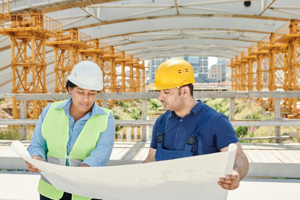 Construction workers reviewing plans, illustrating the need for CG 20 10 Additional Insured - Ongoing Operations coverage.