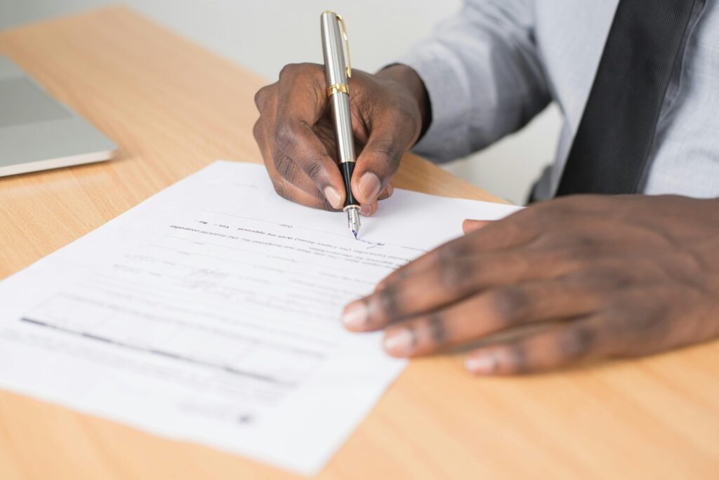 A professional signing an insurance policy document, symbolizing the key differences between occurrence-based and claims-made insurance coverage